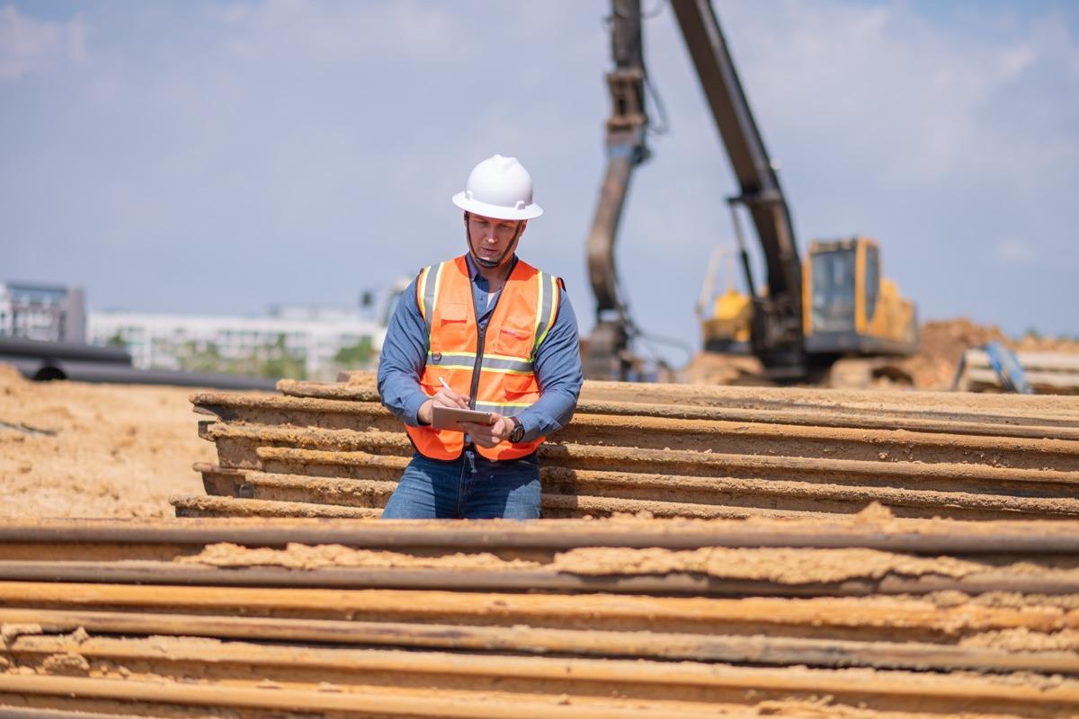 Shop owner reviewing job notes on a clipboard at the site